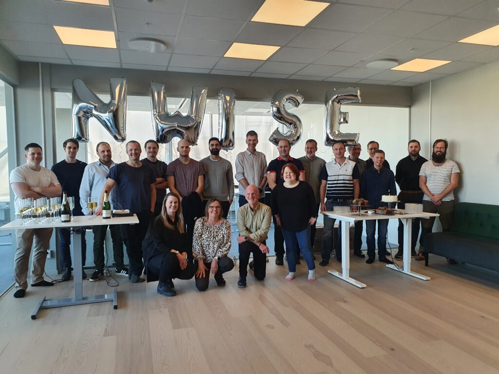 Image of the entire nWise staff in front of silver baloons spelling nWise.